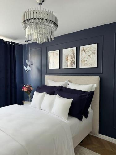 a blue bedroom with a white bed and a chandelier at Elena 100 m2 in Marseille