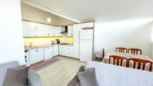 eine Küche und ein Wohnzimmer mit einem Tisch und einer Küchegmaxwell in der Unterkunft Kaan Apart (Ortaca/Dalyan Merkezde) 2+1, 70m2 in Ortaca
