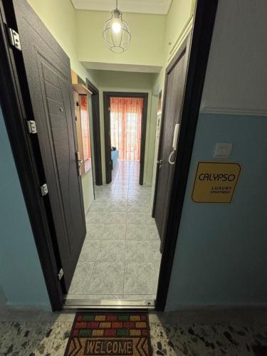 a hallway with two doors and a sign on the wall at Calypso Seaside Apartment in Paleo Tsifliki