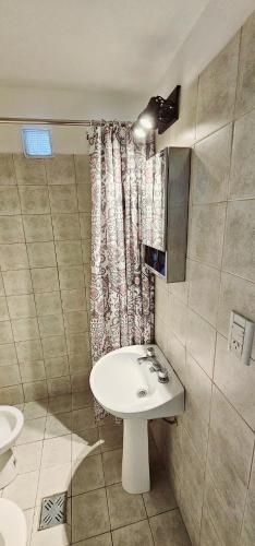 a bathroom with a sink and a shower curtain at LitStay Monoambiente in Córdoba