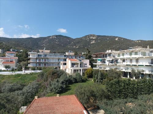a group of buildings with mountains in the background at Calypso Seaside Apartment in Paleo Tsifliki