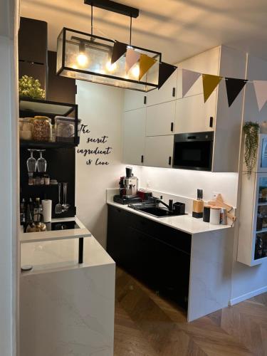 a kitchen with white cabinets and a black and white counter at Paris 16 lux and cozy 2 bedroom in Paris