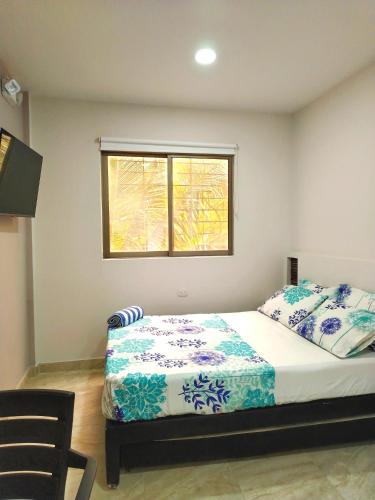a bedroom with a large bed with a window at Avadia del Mar in Cartagena de Indias