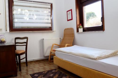 ein Schlafzimmer mit einem Bett, einem Tisch und einem Stuhl in der Unterkunft Drei Linden Siedlung in Wolfenbüttel