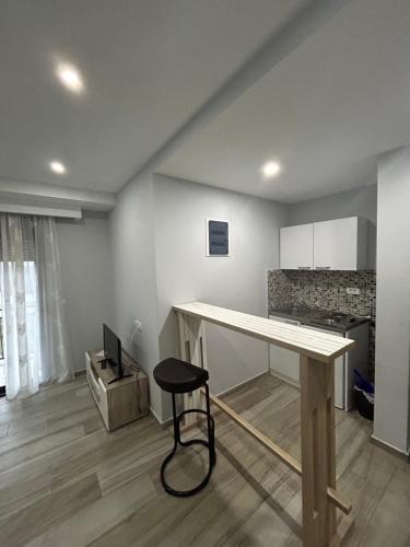 a kitchen with a table and a stool in a room at GuestHouse Moco Forest in Ulcinj