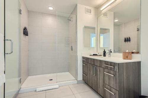 a white bathroom with a shower and a sink at Sentral Michigan Avenue in Chicago