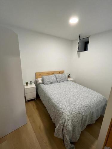 1 dormitorio con 1 cama y TV en la pared en Apartamento Baixo da Barbeira, en Cangas de Morrazo