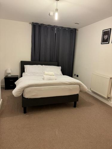 sypialnia z dużym łóżkiem z czarną zasłoną w obiekcie Spacious 2 Bedrooms Apartment In Stratford w Londynie