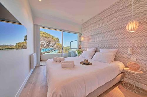 une chambre avec un grand lit avec une grande fenêtre dans l'établissement By the Beach - Beautiful apartment 2 bedrooms - Saint-Tropez - Sea View - Garage, à Saint-Tropez