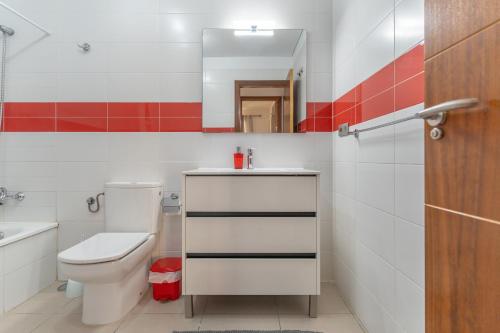 a bathroom with a toilet and a sink and a mirror at Casa More Alcalá Center in Alcalá