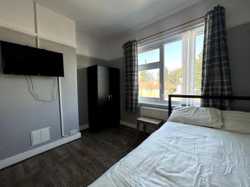 a bedroom with a bed and a large window at Spacious Holiday Home Near Tube Station - By Starlet Stays in London