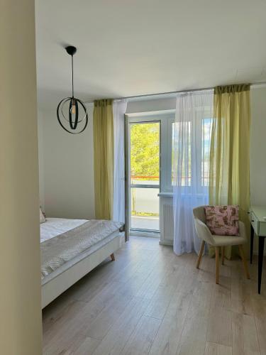シャモリンにあるApartment ZOiのベッドルーム1室(ベッド1台、窓、椅子付)