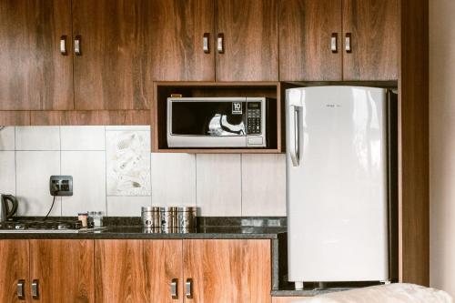 a kitchen with a white refrigerator and a microwave at Umkhaya lodge in Mkuze