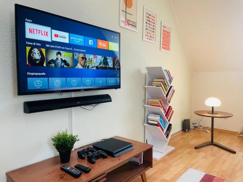 uma sala de estar com uma televisão de ecrã plano na parede em FamilienTraum-Küche-WaschTrockner-PlayStation-NETFLIX-WIFI em Leipzig