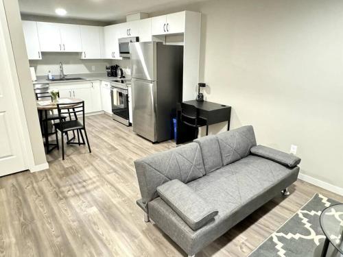 a living room with a couch and a kitchen at Private Luxury Suite Near West Edmonton Mall in Edmonton