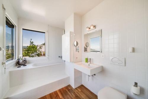 biała łazienka z wanną i umywalką w obiekcie Panoramic 3BD Dream Family Villa in Montreux by GuestLee w mieście Le Châtelard-Montreux