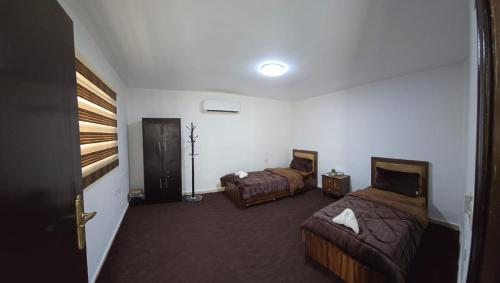 Habitación de hotel con 2 camas y pasillo en Blue Bird House, en Wadi Musa