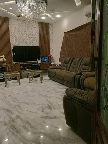 a living room with couches and a flat screen tv at One bedroom flat available for month in al qasmiyah in Sharjah