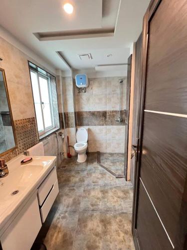 a bathroom with a toilet and a shower and a sink at One bedroom flat available for month in al qasmiyah in Sharjah