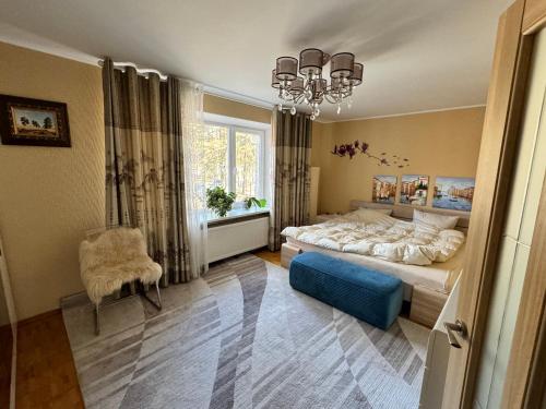 a bedroom with a bed and a chair and a window at VIsagino Apartment in Visaginas