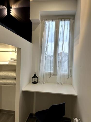 Cette chambre dispose d'une fenêtre avec des rideaux blancs. dans l'établissement appartement proche de Paris Cosy et Lumineux, à Livry-Gargan
