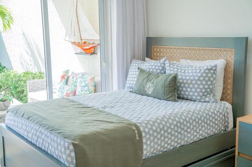 1 dormitorio con cama con almohadas y ventana en Xeliter Green One Playa Dorada, en San Felipe de Puerto Plata