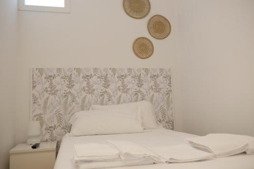 una camera da letto con un letto con lenzuola bianche e un muro di Via Gattini Suite a Matera