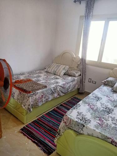 een slaapkamer met 2 aparte bedden en een tapijt bij العين السخنة in Ain Sokhna