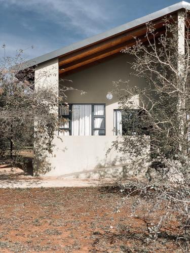 a white house with windows on the side of it at Umkhaya lodge in Mkuze