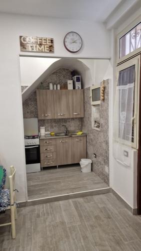 a kitchen with a sink and a clock on the wall at Appartamento intero Casa vacanze Espó in Naples