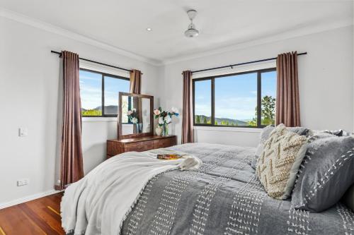 a bedroom with a bed and a large window at Atherton Tablelands - great views, acreage & pet friendly in Tolga