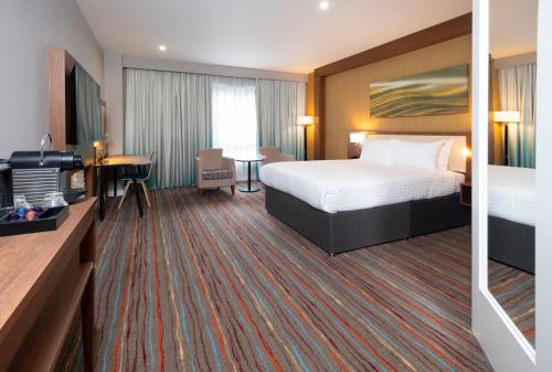 a hotel room with a bed and a desk at Holiday Inn Derby Riverlights by IHG in Derby