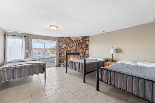 a bedroom with two beds and a fireplace at Lazy Gator House- Sleep 20- Bachelor Parties Welcome in Lake Ozark