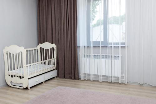 a white crib in a room with a window at Loly Luxury Guest House in Dilijan