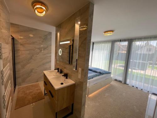 een badkamer met een wastafel en een bed in een raam bij Szil-Luxury Apartman in Zamárdi