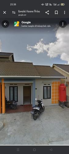 a house with a motorcycle parked in front of it at Sintia House in Sungaidurian