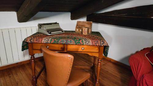a desk with a typewriter on it with a chair at Case sul ruscello in San Sebastiano Da Po