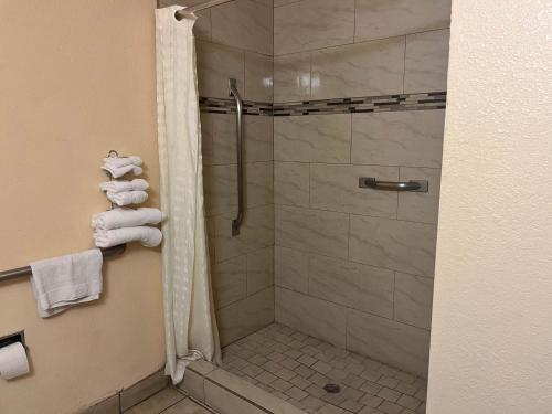 德明Motel 6 Deming, NM的带淋浴和玻璃门的浴室
