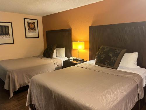 a hotel room with two beds and a lamp at Motel 6 Deming, NM in Deming