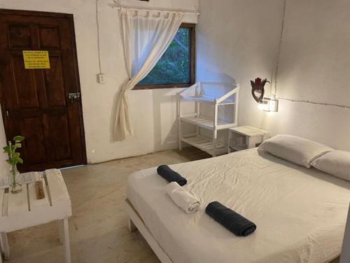 a bedroom with a white bed and a window at HOSTAL CASA DEL ANGEL in Mazunte