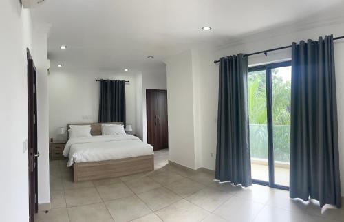 1 dormitorio con cama y ventana grande en Stay Play Away Residences - Luxury 4 bed, Airport Residential, Accra, en Accra