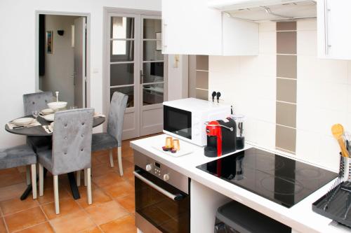 una cucina con bancone, forno a microonde e tavolo di Appartement au coeur du Vieux-Port a Marsiglia