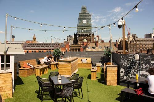 a rooftop patio with tables and chairs on a building at Stunning High Spec Apartment in Leeds City Centre in Leeds