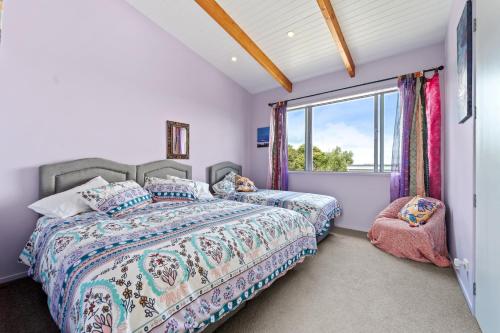 a bedroom with two beds and a window at 923 Takatu - Tawharanui Peninsular Holiday Home in Tawharanui