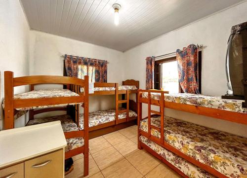 Cette chambre comprend 3 lits superposés et une fenêtre. dans l'établissement Chácara com lazer completo e piscina em Igaratá - SP, à Igaratá