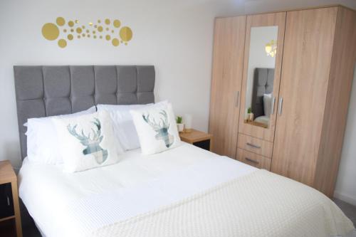 a bedroom with a bed with white sheets and a mirror at Orient Oasis Yarm in Yarm
