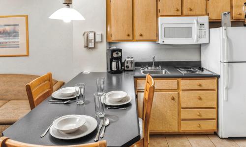 a kitchen with a table with plates and utensils at Hilton Vacation Club Varsity Club Tucson in Tucson