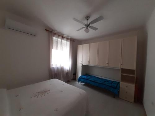 een slaapkamer met een bed en een plafondventilator bij Casa Greta in Iglesias