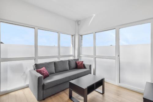 sala de estar con sofá y mesa en SUITE4ME - Moderne Apartments I Küche I Balkon I Waschmaschine, en Dietzenbach