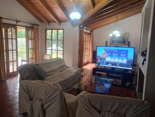 a living room with a flat screen tv and a couch at HERMOSA CASA en CHACRAS DE CORIA in Chacras de Coria